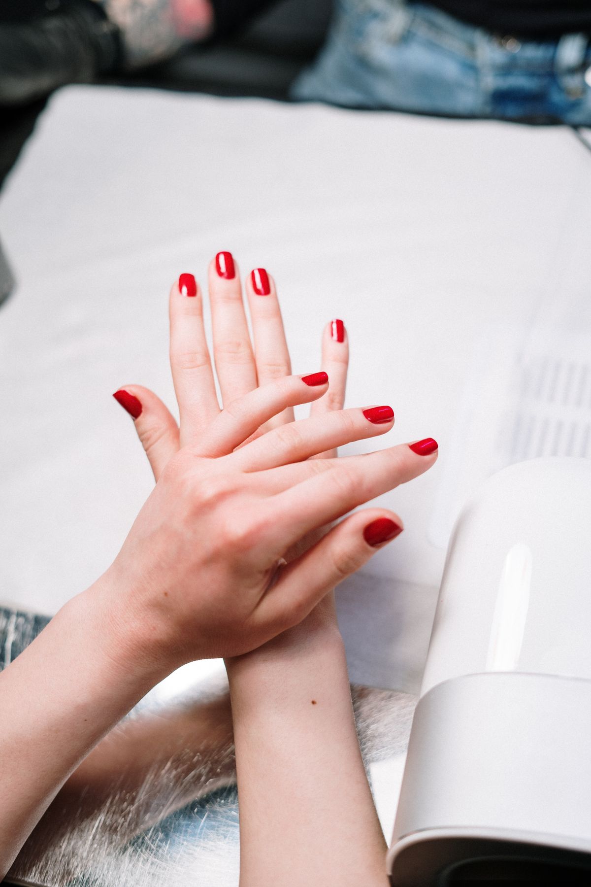 Manicure under UV lamp, representative of services at Angel Nails